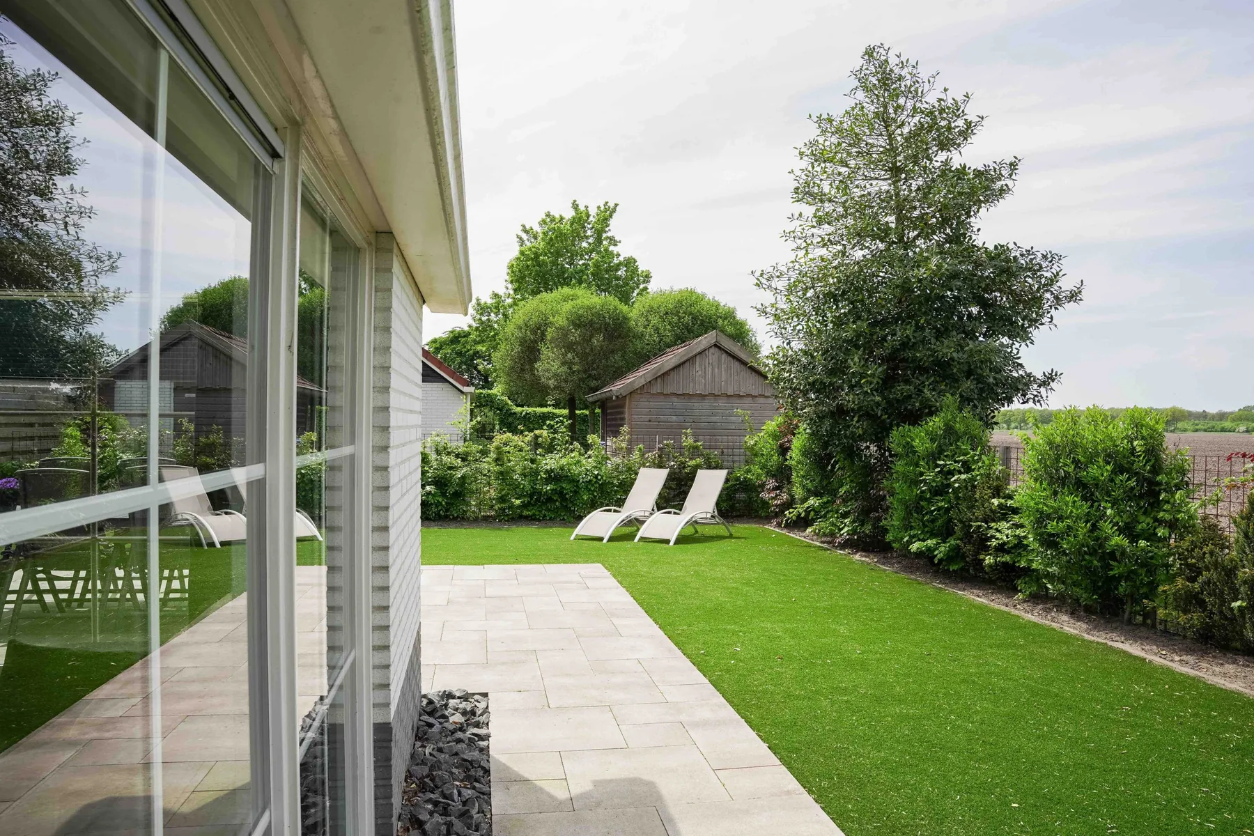 De omheinde tuin van vakantiewoning Bosuil in Appelscha, perfect voor een veilig buitenervaring met je hond.
