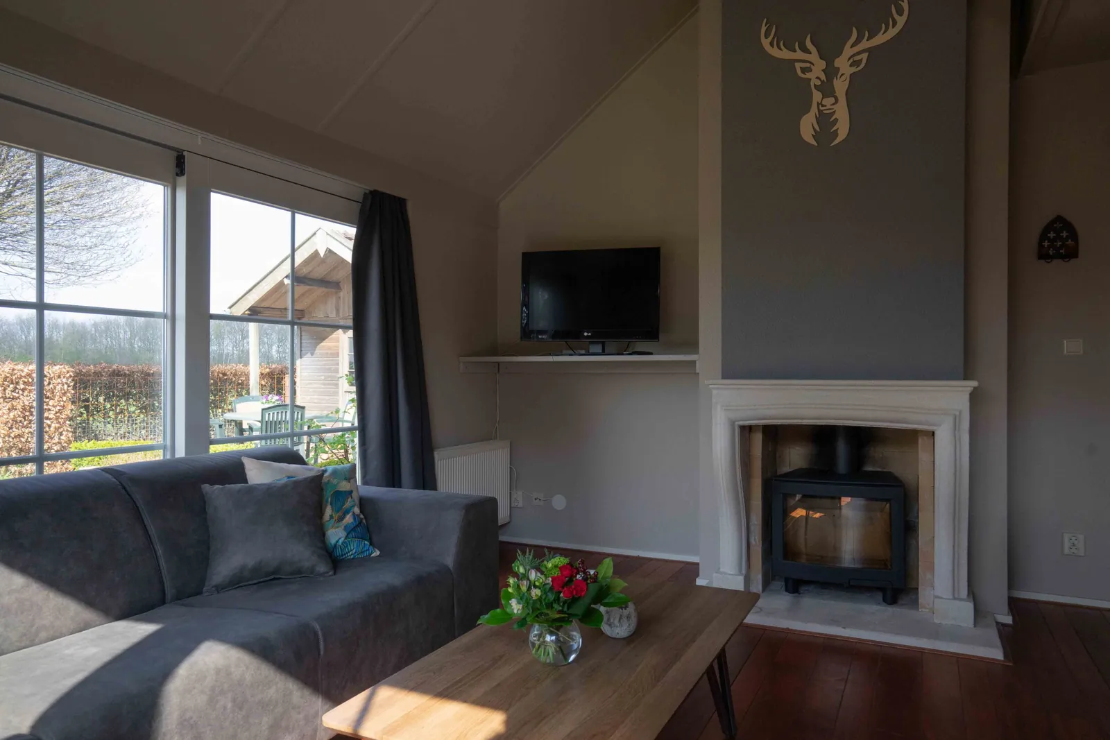 Detail van de sfeervolle houtkachel in de woonkamer van vakantiewoning Nachtegaal, voor extra gezelligheid.